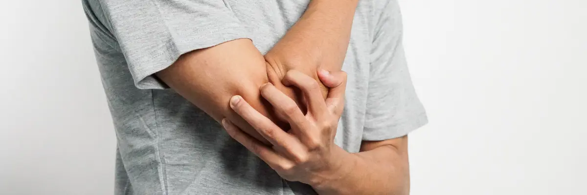 肘の外側の痛み（テニス肘）で悩む人が腕をさすっている様子