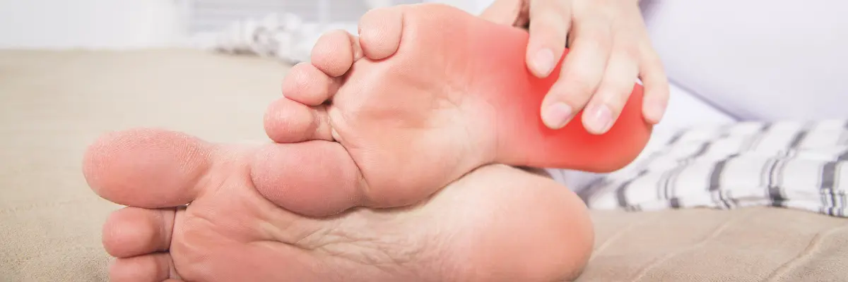 かかとの痛み（足底腱膜炎など）を感じて、足の裏を指し示しているイメージ画像